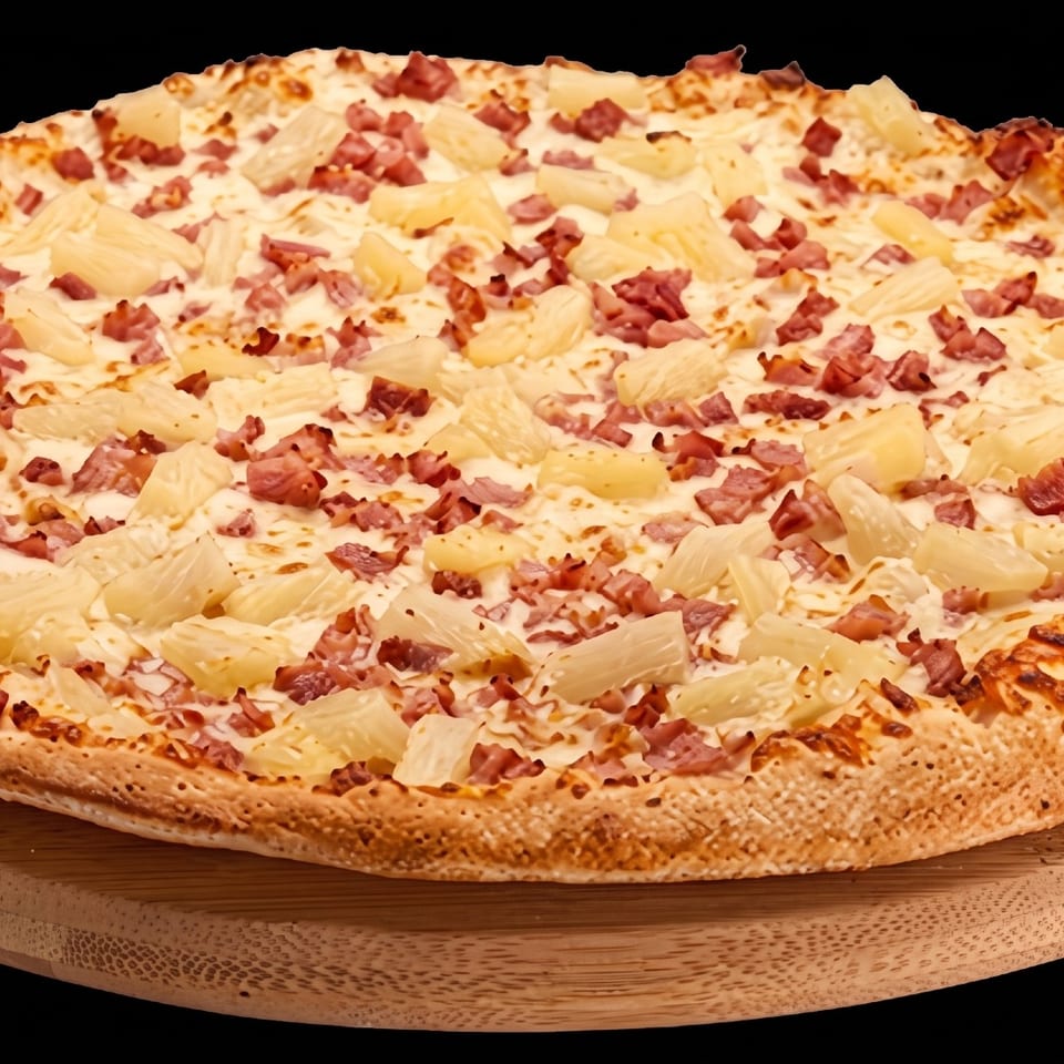 Pizza with pineapple and diced meat on a wooden board.