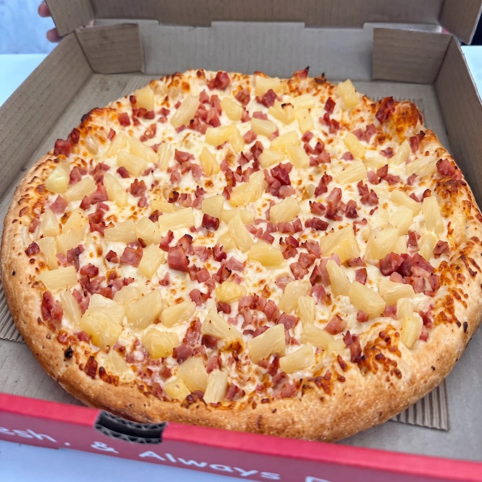 Pizza topped with pineapple and diced meat.
