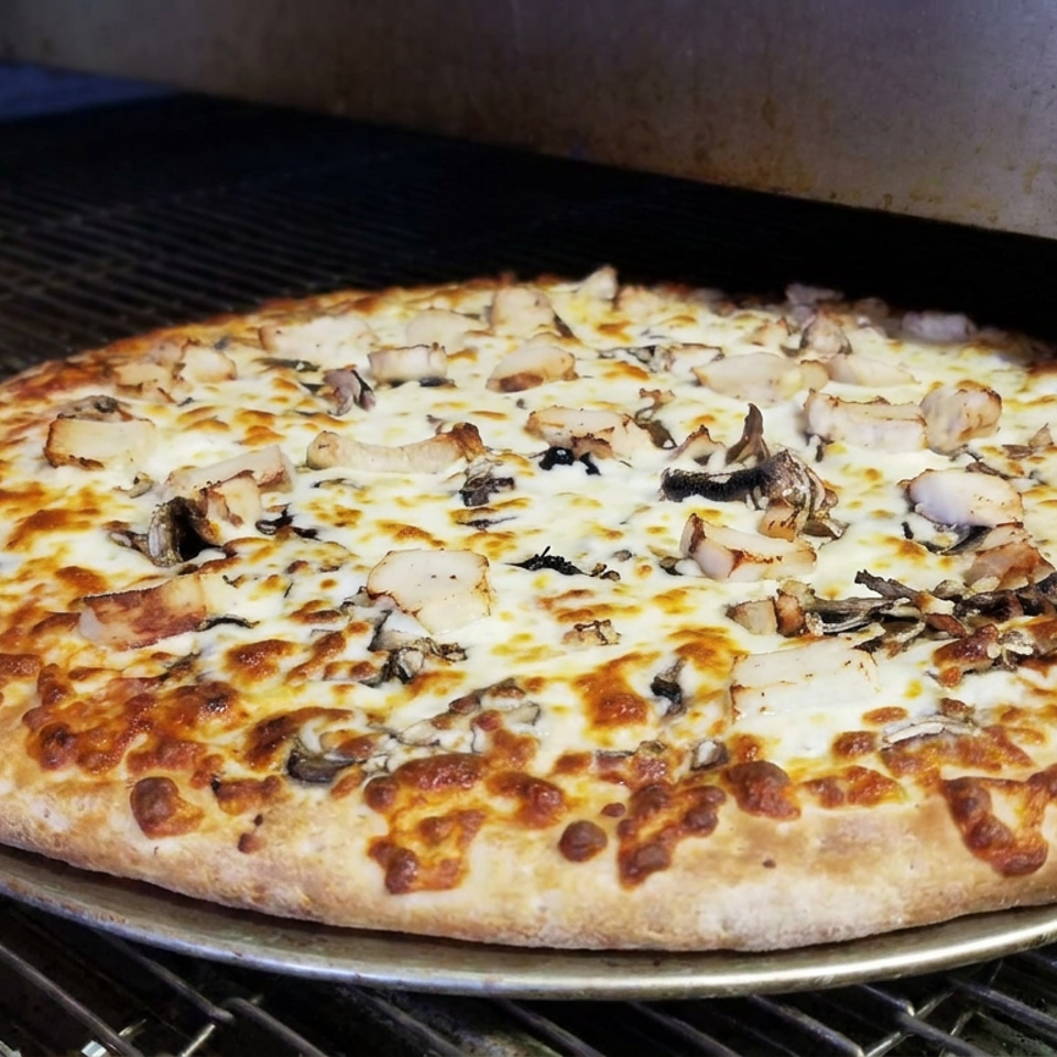 Large freshly baked mushroom and cheese pizza with a golden crust resting on a metal tray inside a commercial oven.